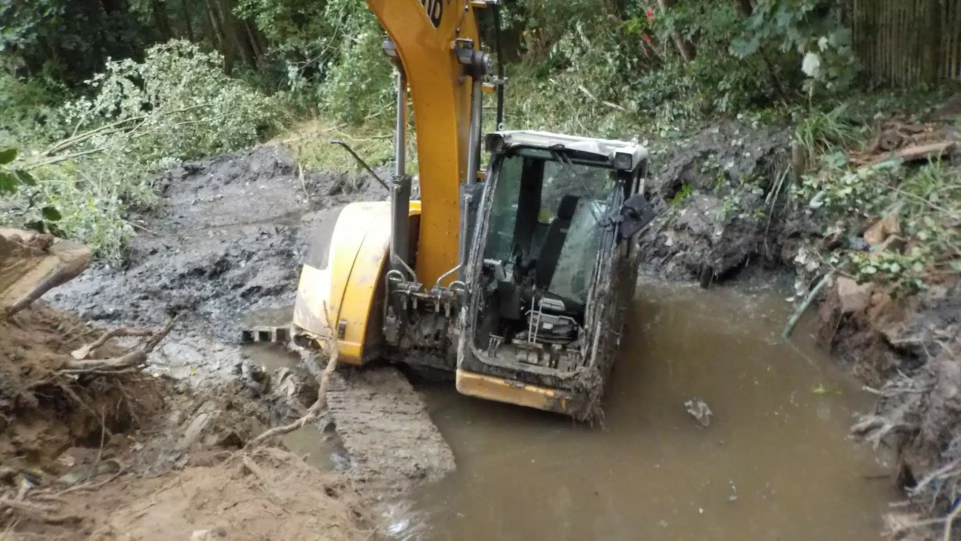 Groundworker driving trench sheets with an excavator on a new drainage scheme near Crowborough